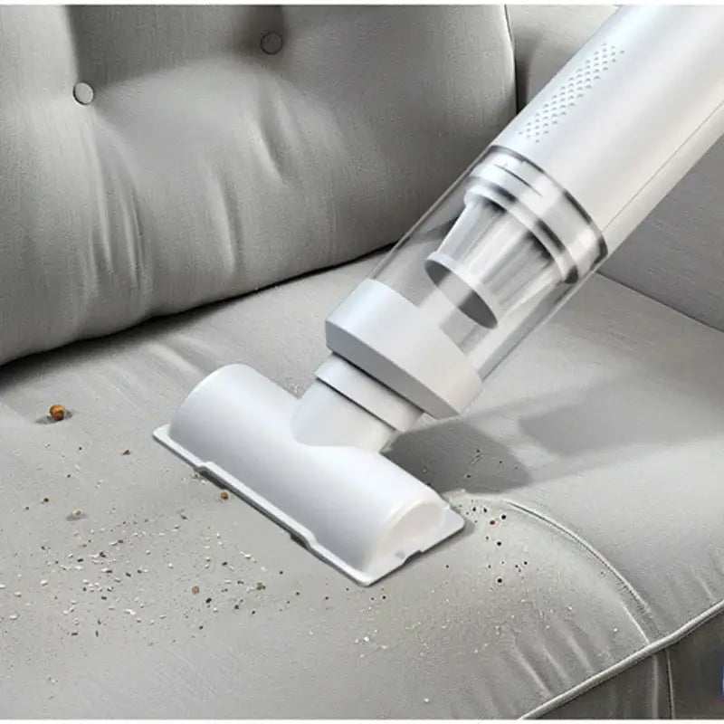 AeroVac One portable vacuum cleaner removing dust and debris from a sofa.